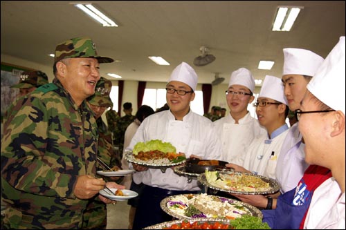 육군 제62사단(사단장 준장 박창희) 충룡부대에서 닭고기 소비 촉진 행사로 '닭고기 요리왕 선발대회를 개최했다. 박창희 사단장과 요리왕 선발대회에 참가한 취사반 장병들. 